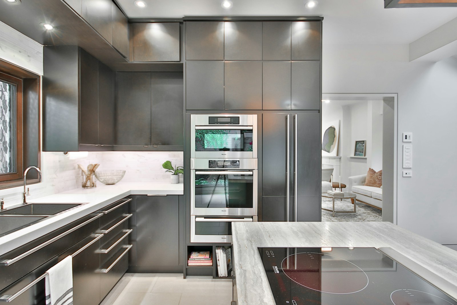 Modern kitchen with matte graphite panel fronts, built-in stainless steel ovens and a paneled refrigerator