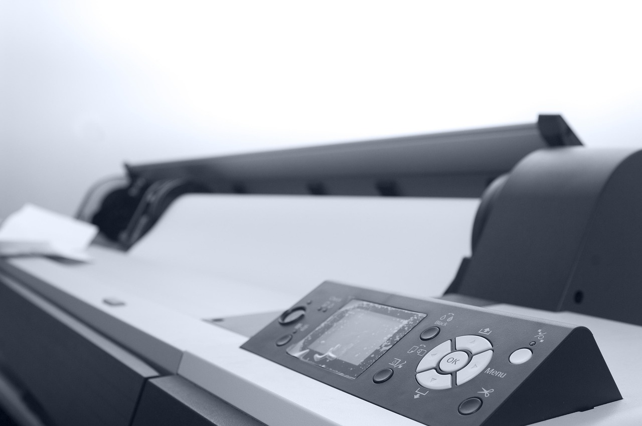 Wide-format inkjet printer with a roll of print media loaded — the class of machine that prints large wall graphics